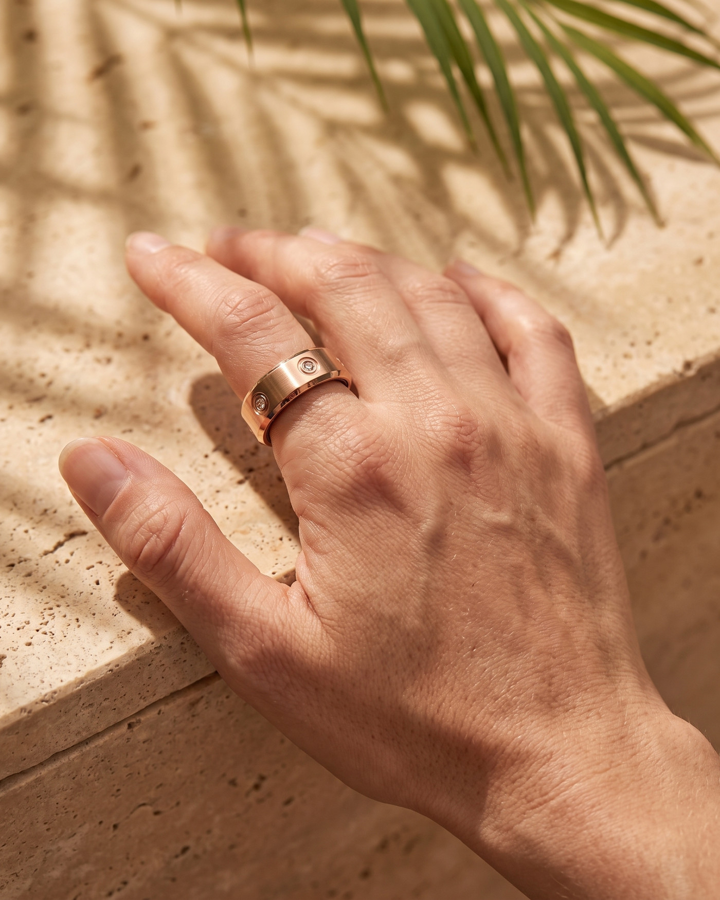 The LuxenX ring worn on the index finger, hand resting on a sunlit balcony rail